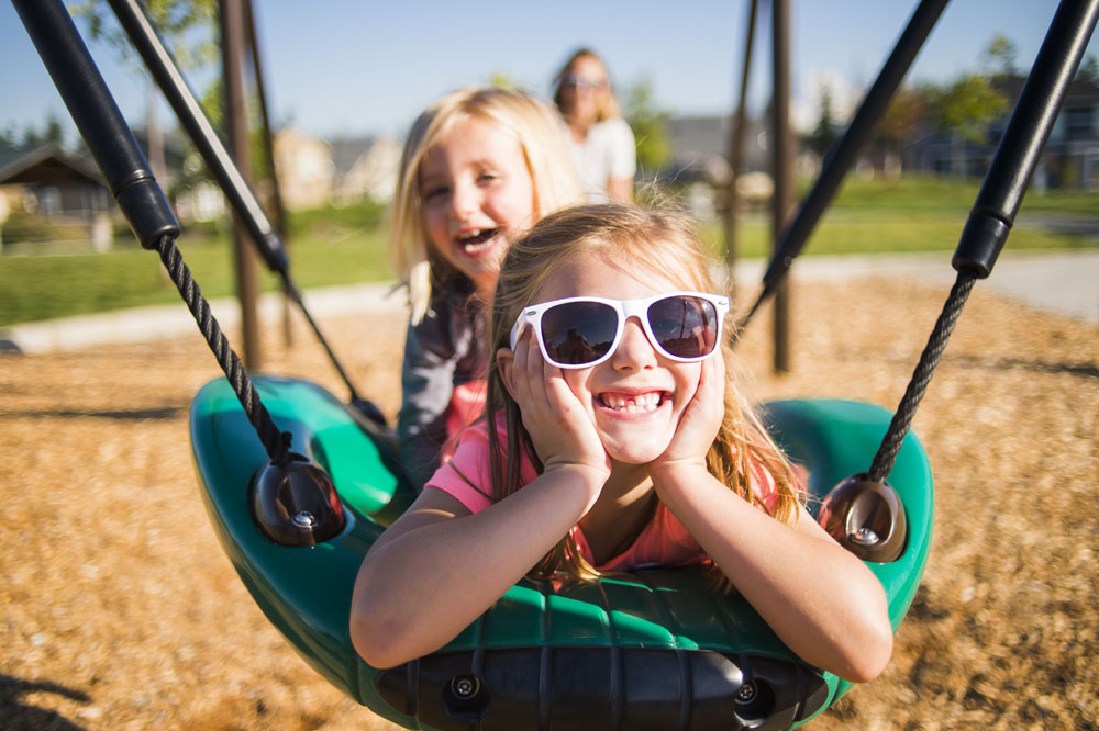 Two sisters smiling on swing