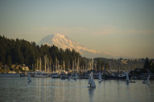 Boats sit in a Gig Harbor marina with Mount Rainier in the background